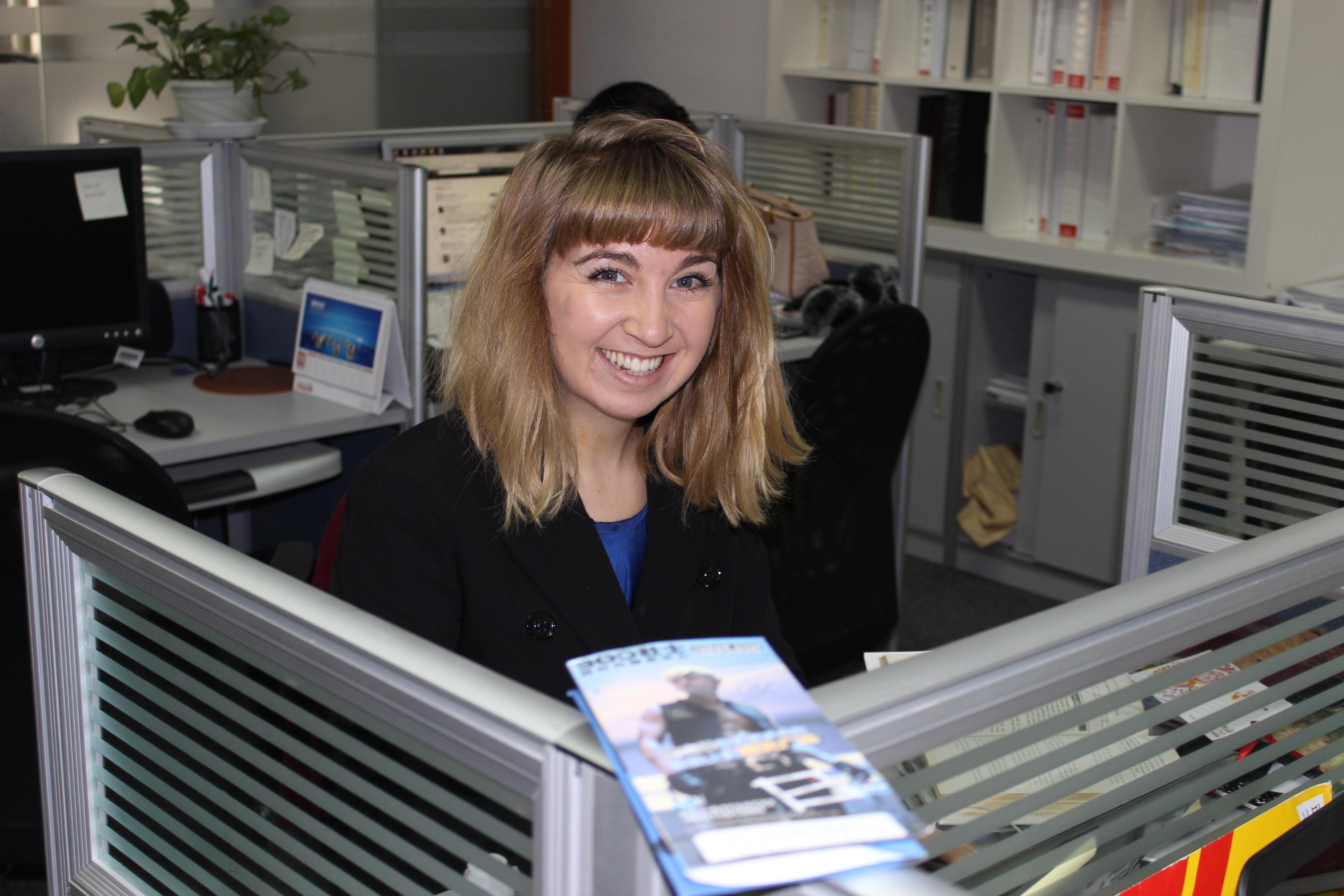 Female Projects Abroad Business Intern smiles for a photo in a consultancy firm during a Business Internship in China. Business intern smiles at her desk in a consultancy firm during her business work placement in Shanghai, China.